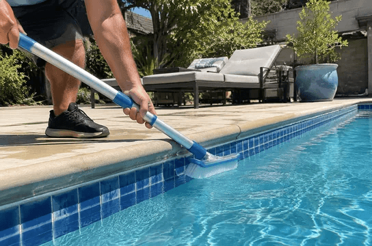 Brushing the tile line of a pool