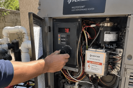 An opened pool heater control panel