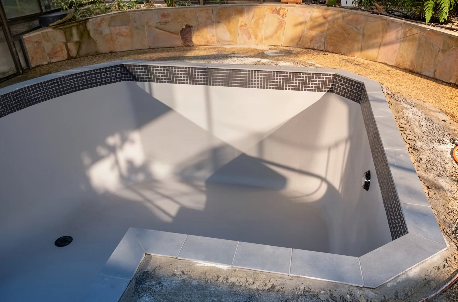 A pool with its shape changed and bluestone paving