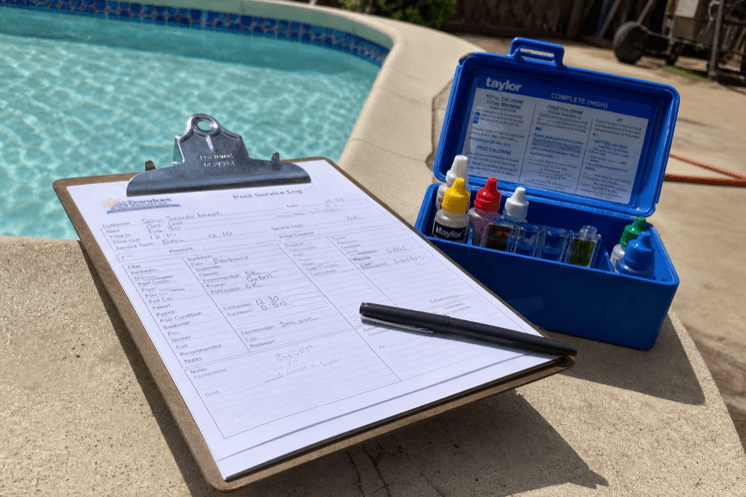 A test kit and clipboard on pool coping