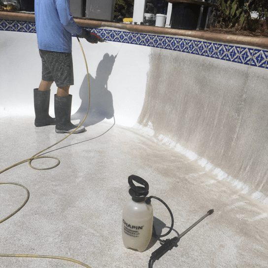 A drained pool half washed back to white