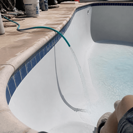 A freshly plastered pool filling with water